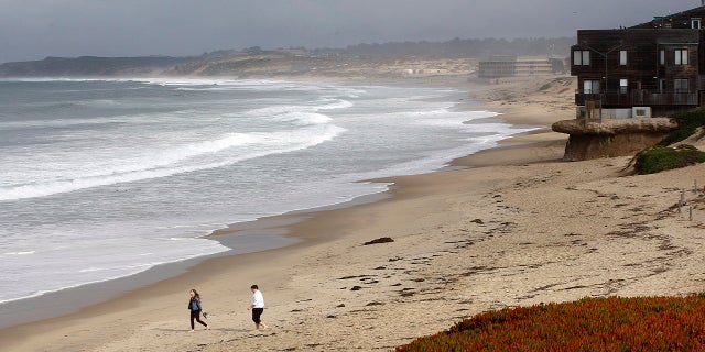 Beachgoers ignore the beach closure signs posted at Monterey State Beach in Monterey, Calif., Jan. 22, 2018.