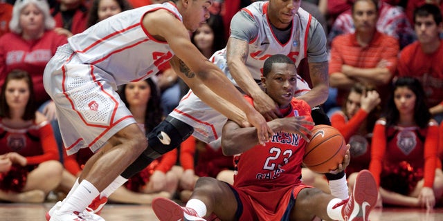 Fresno State's Marvelle Harris (23) hits the floor to recover a loose ball while pressured by New Mexico's Cleveland Thomas, left, and Chad Adams during the first half of an NCAA college basketball game on Saturday, Jan. 12, 2013, in Albuquerque, N.M. (AP Photo/Eric Draper)