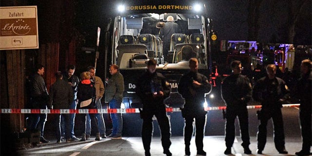 FILE 2017: Authorities stand in front of Dortmund's damaged team bus after explosions which injured two people before the Champions League quarterfinal soccer match between Borussia Dortmund and AS Monaco in Dortmund, western Germany.