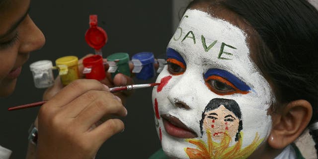 A girl gets her face painted with an awareness message on female foeticide during a face-painting competition in the northern Indian city of Chandigarh August 1, 2009. (REUTERS/Ajay Verma)