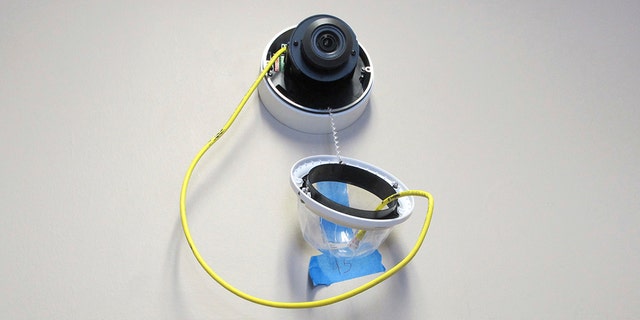 In this July 10, 2018 photo, a camera with facial recognition capabilities hangs from a wall while being installed at Lockport High School in Lockport, N.Y.