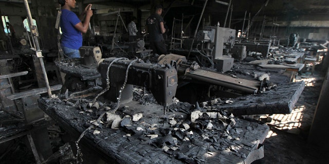 Nov. 26, 2012: A man takes photographs inside a garment-factory where a fire killed more than 110 people on the outskirts of Dhaka, Bangladesh.