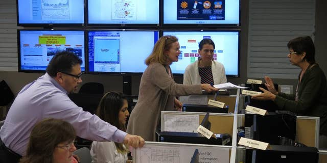 FILE - In this Feb. 24, 2016 file photo, workers from the Puerto Rico Health Department and the Centers for Disease Control and Prevention review Zika-related data collected by the island's health department and the CDC in San Juan, Puerto Rico. On Friday, June 17, 2016, Dr. Tom Frieden, the director of the CDC, is warning that dozens or hundreds of babies in Puerto Rico could develop severe birth defects because of the virus, based on how an outbreak is playing out there. (AP Photo/Danica Coto)