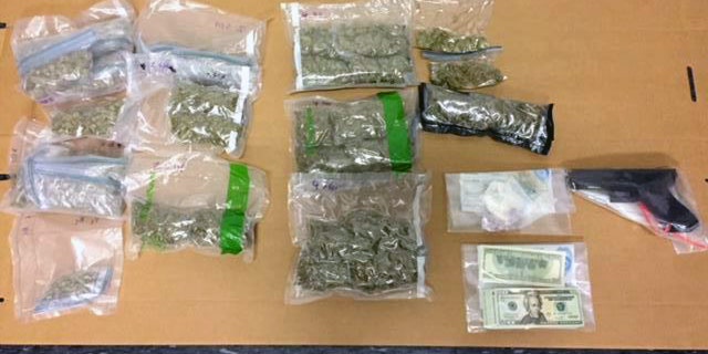Police display marijuana and other paraphernalia seized from a suspected drug dealer