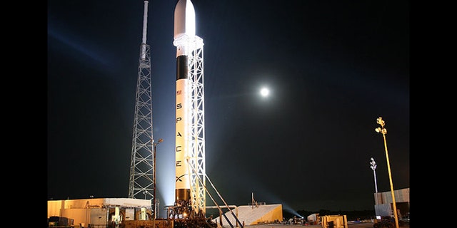 A Falcon 9 rocket from SpaceX sits on a launch pad, awaiting take off.
