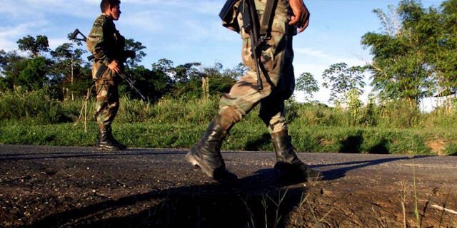 CAQUETA, COLOMBIA - JULY 31: Colombian soldiers patrol the highway that leads to San Vicente del Caguan from their base in Caqueta, Colombia on July 31, 2002. Despite a strong military presence in the former demilitarized zone, FARC guerrillas still maintain their control over the territories. (Photo by Carlos Villalon/Getty Images.)