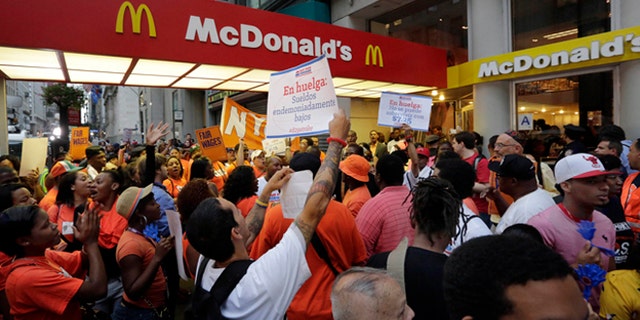 FILE: Aug. 29, 2013: Fast food workers demonstrate outside a McDonald's on New York's Fifth Avenue to get such fast-food chains to pay workers higher wages.