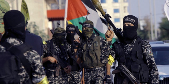 Masked militants from Nabil Masoud Brigades, a military wing of the Fatah movement, hold their weapons during a parade against Israeli arrangements in a contested Jerusalem shrine, along the streets of Gaza City, July 25, 2017.