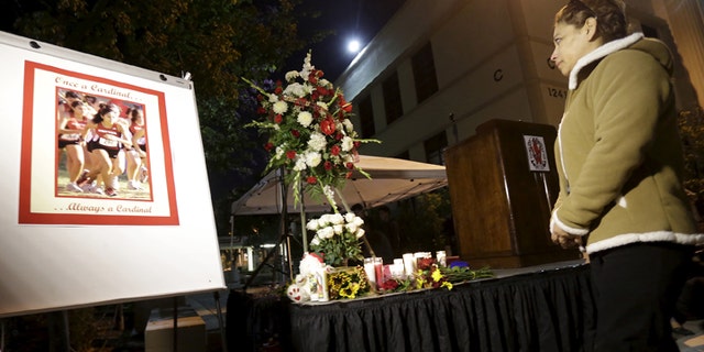 A woman stands at a makeshift shrine to honor Whittier High School alumna Nohemi Gonzalez, who was killed in the Paris terror attack last week, during a candlelight vigil in Whittier, California November 17, 2015. REUTERS/Jonathan Alcorn - GF20000064180