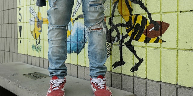An Alameda High School student poses for photos wearing ripped jeans on the school's campus.