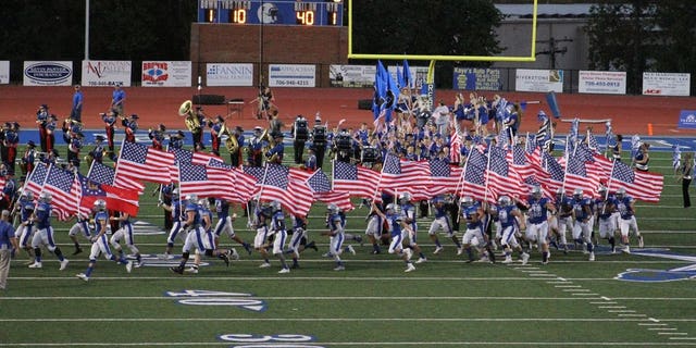 A Georgia high school football team ran onto the field Friday night waving American flags.