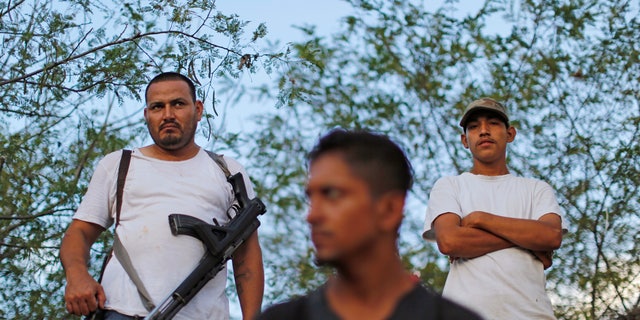 In this Nov. 5 photo, armed men from to a self-defense group create a checkpoint in the town of Las Colonias, Mexico. Several communities have created their own self-defense groups after a pseudo-religious cartel, known as the "Knights Templar," has for years demanded protection payments from cattlemen, lime growers and other businesses. The groups say they are free of the cartel in several municipalities of the Tierra Caliente, or “Hot Land,” which earned its moniker for the scorching weather but whose name has also come to signify criminal activity. (AP Photo/Dario Lopez-Mills)