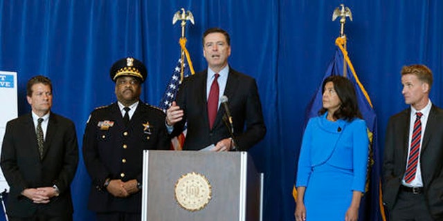 FBI Director James B. Comey, center, announces the addition of Luis Macedo to the bureau's ten most wanted list during a news conference, Thursday, May 19, 2016, in Chicago.