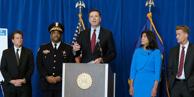 FBI Director James B. Comey, center, announces the addition of Luis Macedo to the bureau's ten most wanted list during a news conference, Thursday, May 19, 2016, in Chicago.