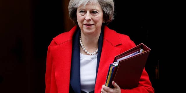 FILE - In this Wednesday, Nov. 23, 2016 file photo, Britain's Prime Minister Theresa May leaves 10 Downing Street to attend the weekly Prime Ministers' Questions session, in parliament in London. Prime Minister Theresa May's office says Thursday Jan. 5, 2017, the British leader will meet Donald Trump in Washington in the weeks following his Jan. 20 inauguration as U.S. president. (AP Photo/Kirsty Wigglesworth, File)