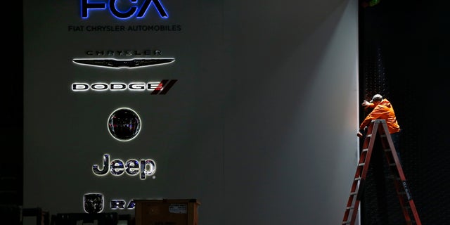 FILE - In this Thursday, Jan. 7, 2016, file photo, a worker prepares the Fiat Chrysler Automobiles area for the North American International Auto Show in Detroit. Fiat Chrysler Automobiles announced Thursday, Sept. 15, 2016, that the company is recalling more than 1.9 million vehicles worldwide because their air bags might not deploy in a crash. The recall affects certain Chrysler, Dodge, Jeep and Lancia vehicles from the 2010-2014 model years. (AP Photo/Paul Sancya, File)