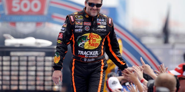 Driver Tony Stewart greets fans as he is introduced before the NASCAR Daytona 500 Sprint Cup series auto race at Daytona International Speedway in Daytona Beach, Fla., Sunday, Feb. 23, 2014. (AP Photo/John Raoux)