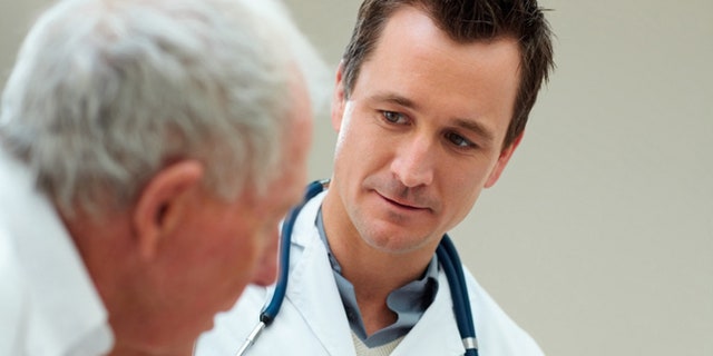 Handsome successful doctor speaking to a senior patient