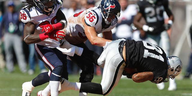 Oakland Raiders tight end Mychal Rivera, right, is brought down with the ball by Houston Texans inside linebacker Brian Cushing (56) as Texans strong safety D.J. Swearinger (36) looks on in the third quarter of an NFL football game Sunday, Sept. 14, 2014, in Oakland, Calif. (AP Photo/Beck Diefenbach)