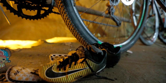 A pair of soccer shoes are left next to bicycles from a group of missing boys at the entrance of a deep cave in Chiang Rai, northern Thailand.