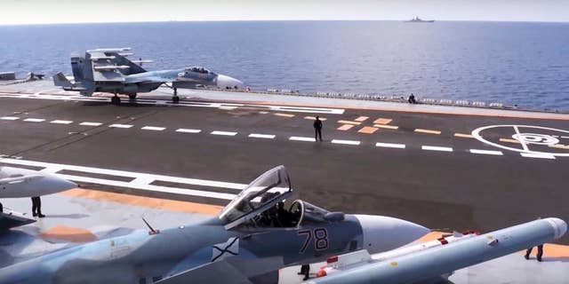 FILE - In this file photo made from the footage taken from Russian Defense Ministry official web site on Tuesday, Nov. 15, 2016, Russian Su-33 fighter jets stand on the flight deck of the Admiral Kuznetsov aircraft carrier in the eastern Mediterranean Sea. Russia says it is withdrawing the Admiral Kuznetsov aircraft carrier and some other warships from the waters off Syria as the first step in drawing down forces in Syria. (Russian Defense Ministry Press Service/ Photo via AP, File)