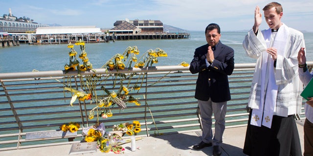 Father Cameron Faller and Julio Escobar conduct a vigil for Kathryn Steinle on Pier 14 in San Francisco, July 6, 2015.