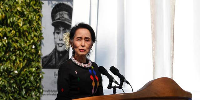 Myanmar State Counsellor Aung San Suu Kyi, standing by a portrait of her late father and national hero Gen. Aung San and the Panglong monument, delivers a speech during a ceremony to mark the 70th anniversary of Union Day Sunday, Feb.12, 2017, in Panglong, Southern Shan State, over 800 kilometers (500 miles) northeast of Yangon, Myanmar. (AP Photo/Thein Zaw)