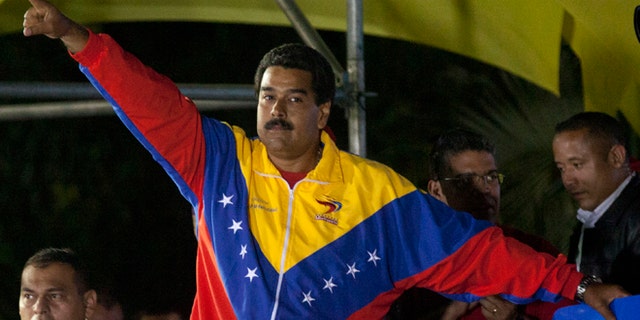 Venezuela's newly elected President Nicolas Maduro celebrates his victory after the official results of the presidential elections were announced, at the Miraflores Palace in Caracas, Venezuela, late Sunday, April 14, 2013. Maduro, Hugo Chavez's hand-picked successor, won a razor-thin victory in Sunday's special presidential election, edging the opposition leader Henrique Capriles by only about 300,000 votes, electoral officials announced. (AP Photo/Ramon Espinosa)