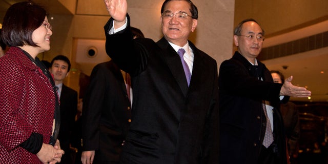 Taiwan's former vice president Lien Chan, center, waves to journalists upon arrival at a hotel in Beijing Sunday, Feb. 24, 2013. Lien Chan leads a business and politician delegation to Beijing for a three day visit and will meet with Chinese President Hu Jintao and Communist Party Secretary General and the country's new leader Xi Jinping. (AP Photo/Andy Wong)