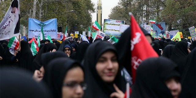 Iranian demonstrators attend an annual gathering in front of the former U.S. Embassy, marking the anniversary of its 1979 takeover, while a surface-to-surface missile is displayed Saturday