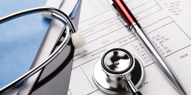 stethoscope and pen resting on a sheet of medical lab test results, with patient file and x-ray or mri film