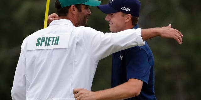Jordan Spieth hugs his caddie Michael Greller after winning the Masters golf tournament Sunday, April 12, 2015, in Augusta, Ga. (AP Photo/Chris Carlson)