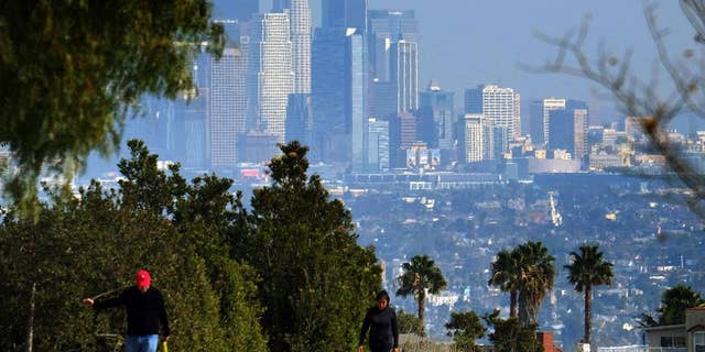 Hikers walk along a path at the Kenneth Hahn State Recreation Area near downtown Los Angeles on Sunday, Jan. 3, 2016. Southern California is bracing for a series of storms expected to begin late Sunday that could last all week. (AP Photo/Richard Vogel)