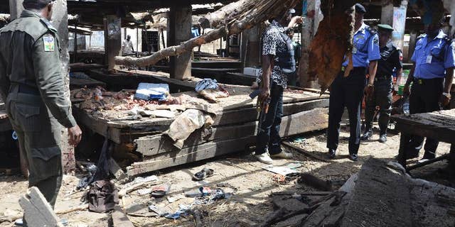Police officers inspect the site of a suicide bomb attack at a market in Maiduguri , Nigeria, Tuesday, June 2, 2015. Boko Haram attacked the northeastern Nigerian city of Maiduguri on Tuesday with deafening explosions from the west and a suicide bombing near the center that witnesses said killed as many as 20 people. (AP Photo/Jossy Ola)