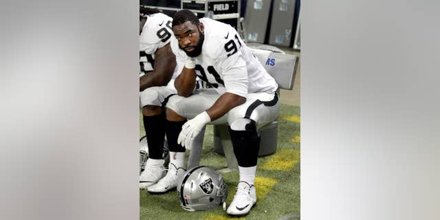 Oakland Raiders defensive end Justin Tuck sits on the bench during the fourth quarter of an NFL football game against the St. Louis Rams, Sunday, Nov. 30, 2014, in St. Louis. (AP Photo/Tom Gannam)