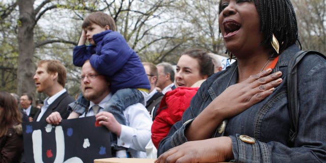 Esther Mayberry, with the State Department, right, sings "America the Beautiful" during a rally of U.S. diplomats and federal workers against the prospect of a government shutdown, Friday, April 8, 2011, in Washington. (AP)