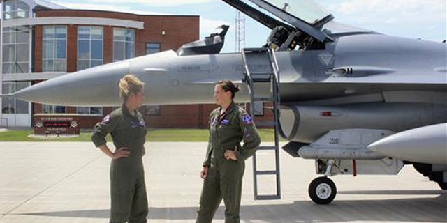 In this Tuesday, July 19, 2016, photo, Capt. Valerie Vanderostyne, left, and Capt. Shanon Davis, both with the South Dakota Air National Guard, chat alongside an F-16 Fighting Falcon at Joe Foss Field in Sioux Falls, S.D.