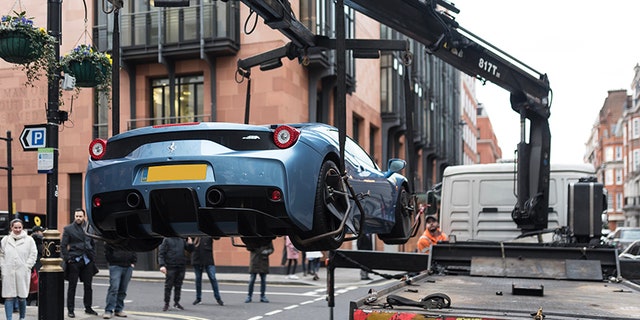 This is the moment cops in London seized a limited edition Ferrari worth half a million pounds - because its young owner didn't have car insurance. See SWNS story SWFERRARI; Stunned onlookers in posh Mayfair watched the bizarre scene unfold on Sunday afternoon as the Ferrari 458 Speciale Aperta, one of only 499 ever made, was lifted onto a towing truck. Cops said the driver was reported on suspicion of using the expensive car, which is even more sought-after because it is one of the few with a right-hand drive, without insurance. An eyewitness said:"The young man was in a baby blue Ferrari worth probably around Â£600,000."He was driving in convoy through Mayfair with his dad who was in a Porsche 918."