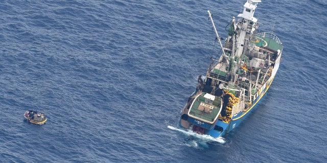 A wooden dinghy, left, carrying seven survivors from a missing ferry and a fishing boat in the Pacific Ocean, Jan 28, 2018.
