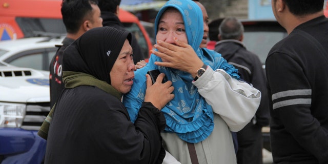 Relatives of victims of a sunken ferry weep as they wait for news on the search efforts.