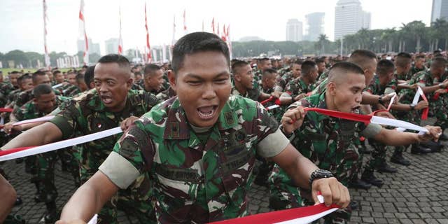 Indonesian soldiers perform national flag -colored headbands during a military-sponsored interfaith rally held ahead of the planned Dec. 2 Muslim protest against Jakarta Governor Basuki Tjahaja Purnama in Jakarta, Indonesia, Wednesday, Nov. 30, 2016. Thousands of Indonesians have joined interfaith rallies around the country organized by the military in an attempt to demonstrate national unity as religious and racial tensions divide the world’s largest Muslim nation. (AP Photo/Achmad Ibrahim)