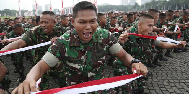 Indonesian soldiers perform national flag -colored headbands during a military-sponsored interfaith rally held ahead of the planned Dec. 2 Muslim protest against Jakarta Governor Basuki Tjahaja Purnama in Jakarta, Indonesia, Wednesday, Nov. 30, 2016. Thousands of Indonesians have joined interfaith rallies around the country organized by the military in an attempt to demonstrate national unity as religious and racial tensions divide the world’s largest Muslim nation. (AP Photo/Achmad Ibrahim)