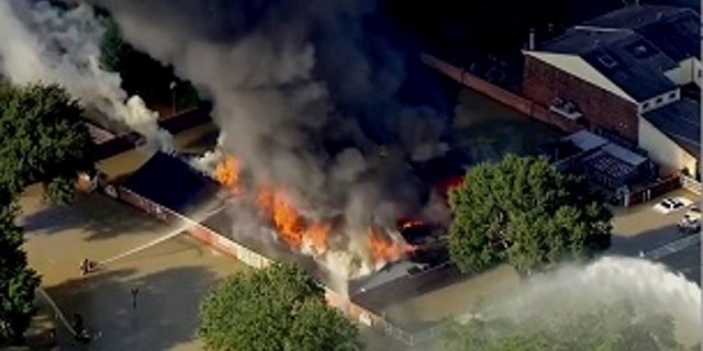 Firefighters were battling a blaze at a Houston building surrounded by floodwaters.