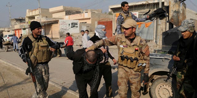 Iraqi security forces arrest a suspected fighter with the Islamic State group during a military operation to regain control of the eastern side of Mosul, Iraq, Wednesday, Jan. 4, 2017. (AP Photo/ Khalid Mohammed)