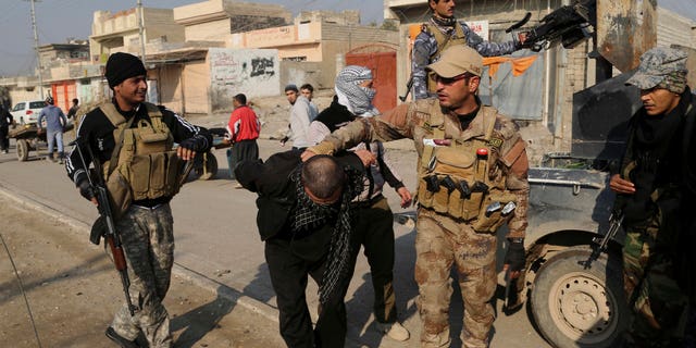Iraqi security forces arrest a suspected fighter with the Islamic State group during a military operation to regain control of the eastern side of Mosul, Iraq, Wednesday, Jan. 4, 2017. (AP Photo/ Khalid Mohammed)