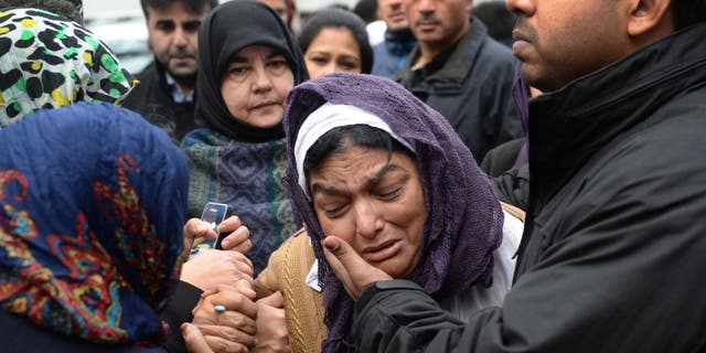 Fatima Khan, mother of Dr Abbas Khan 32, who died while being held in custody in Syria, is comforted by her son at a service for the British doctor at Regent's Park mosque in central London, Thursday, Dec. 26, 2013. Dr Abbas Khan was on the verge of being released when his family were told of his death. The Syrian regime claimed he took his own life but his family claim he was murdered. (AP Photo/Stefan Rousseau, PA Wire) UNITED KINGDOM OUT - NO SALES - NO ARCHIVES