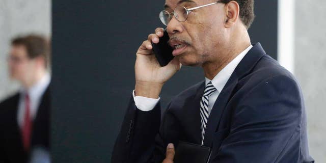 FILE - In this July 30, 2015, file photo, former Illinois U.S. Rep. Mel Reynolds talks on his cell phone as he leaves federal court in Chicago. Reynolds says he no longer wants to plead guilty to misdemeanor federal tax charges. In a hand-written court filing Tuesday, May 17, 2016, Reynolds said he wants to be released to a Chicago halfway house where he believes he can better prepare for his June 20 trial. (AP Photo/M. Spencer Green, File)