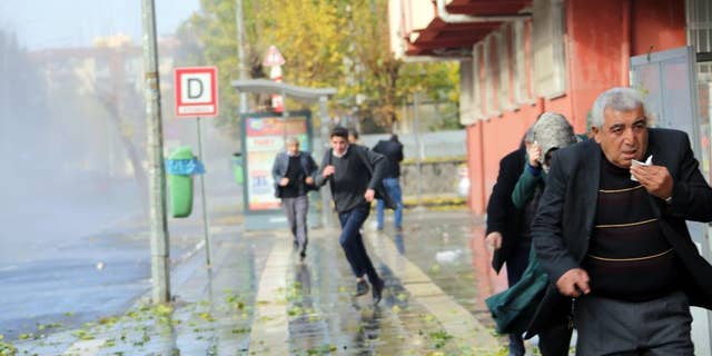 Police use water cannons and teargas to break up a protest by some 5,000 people, denouncing a government-imposed curfew in the historical city center, in Diyarbakir, Turkey, Monday, Dec. 14, 2015. Turkey is imposing dayslong curfews in towns and districts in southeast Turkey as the security forces battle Kurdish militants who dig up ditches or set up barricades.(AP Photo/Mahmut Bozarslan)