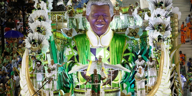 Performers from the Imperatriz Leopoldinense samba school parade in a float with the sculpture depicting Nelson Mandela, during carnival celebrations at the Sambadrome in Rio de Janeiro, Brazil, Tuesday, Feb. 17, 2015. (AP Photo/Leo Correa)