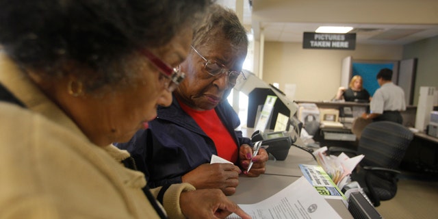 Dorothy Melvin, center, gets help in Tennessee from Charline Kilpatrick in getting a license with a photograph that will be valid at polling stations.